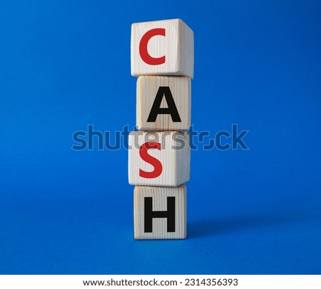 Cash symbol. Concept word Cash on wooden cubes. Beautiful blue background. Business and Cash concept. Copy space.