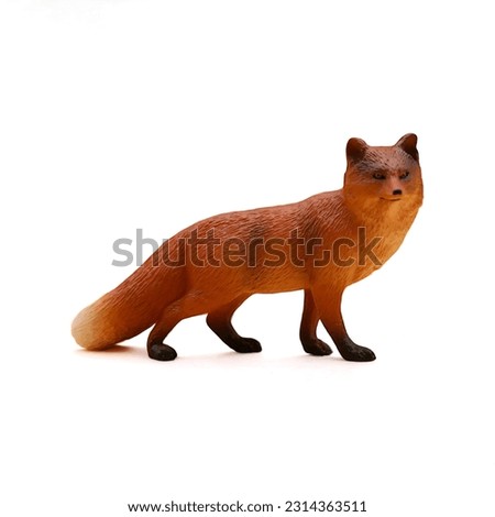 Close-up of a miniature toy fox animal side view on a white background