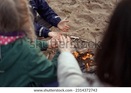 family warming hands over campfire. Touristic concept. High quality photo
