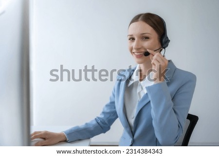 Call center agent woman with headset working on support hotline in modern office. Smiling female customer support phone operator at workplace. Royalty-Free Stock Photo #2314384343