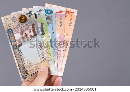 Bahraini money - dinar in the hand on a gray background Royalty-Free Stock Photo #2314385001