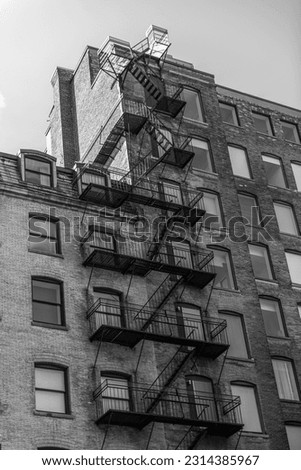 Black and white photo of the exterior of a building in Montreal with a fire escape