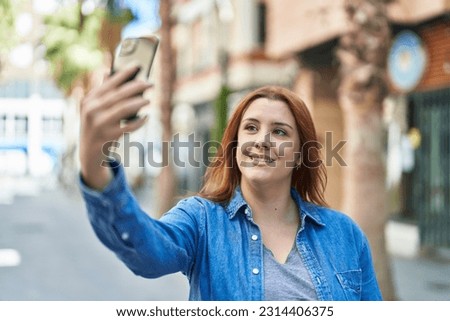 Young beautiful plus size woman smiling confident making selfie by the smartphone at street