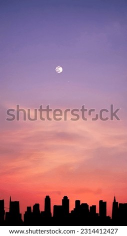 Vertical image, full moon in dramatic vibrant color clouds and sky with silhouette city skyline, twilight, nature wallpaper background Royalty-Free Stock Photo #2314412427