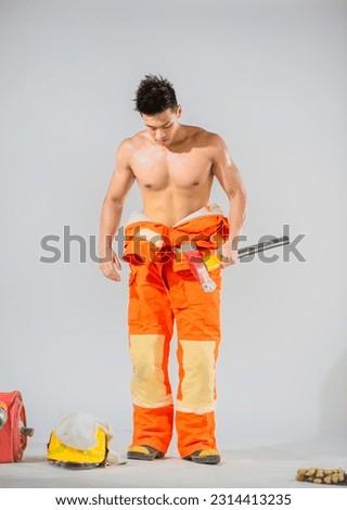 Front view of topless firefighter standing and holding an iron axe on white background, Danger workers, Helping and saving people concept.