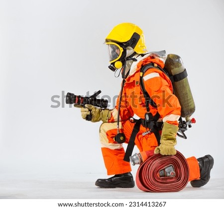 Firefighter kneeling down on the white background  maintains a strong and steady posture while firmly gripping the fire hose in his hands.