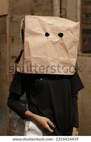 A girl with a box on his head and pointing fingers