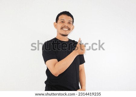 Happy asian man shows thumb up as a good hand sign isolated on white background.