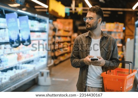 Handsome man shopping in a supermarket.