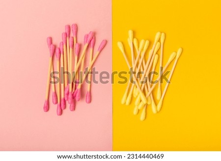 Cotton buds on a yellow-pink background.Cotton Swab.Clean cotton buds. hygiene product. Ear sticks. Place for text. Place to copy. Close-up. Flat lay.