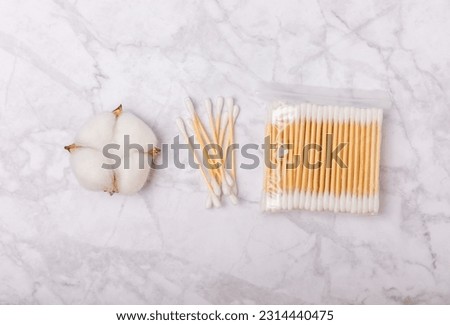 Cotton buds on a white marble background.Cotton Swab.Clean cotton buds. hygiene product. Ear sticks. Place for text. Place to copy. Close-up. Flat lay.
