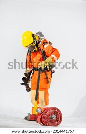 Side view of firefighter stands on a white background using an iron axe on the ground while an oxygen tank behind his back with the other and looked down to the floor.