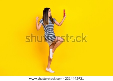 Photo of crazy excited lady wear stylish clothes recording vlog live stream celebrating victory isolated on yellow color background