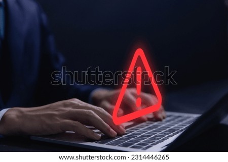 Businessman using laptop showing warning triangle and exclamation sign icon Warning of dangerous problems Server error. Virus. Maintenance concept. caution internet technology network security Royalty-Free Stock Photo #2314446265