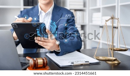 Judge in a courtroom using laptop and tablet with AML anti money laundering icon on virtual screen. Royalty-Free Stock Photo #2314451661