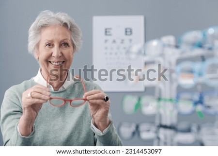 Senior woman trying new prescription glasses and smiling, eye care concept Royalty-Free Stock Photo #2314453097