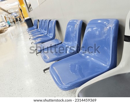 Empty chairs arranged in front of the grey wall. Waiting room in medical office interior with chairs.