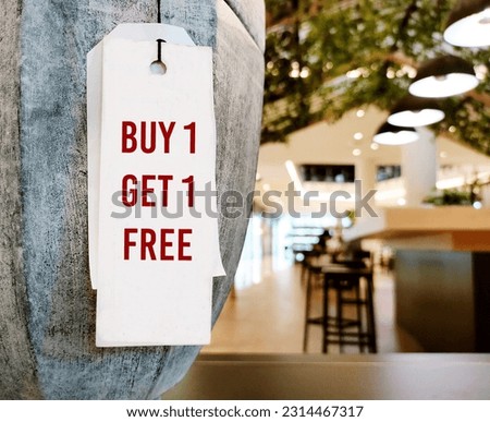 Price tag hanging on product item in store with text written BUY 1 GET 1 FREE, common form of sales promotion- deal involves offering a second product for the first price to attract customers Royalty-Free Stock Photo #2314467317
