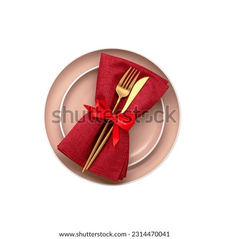 Golden cutlery on red napkin and plate. The object is isolated on a white background. View from above. Flat lay design. Top view. Table knife and fork tied with ribbon. Menu template.
