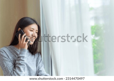 Lifestyle beautiful beauty woman Asian cute girl feel happy talking on smartphone to best friend in bedroom at home
