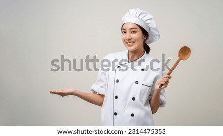 Young beautiful asian woman chef in uniform holding ladle utensils cooking in the kitchen various gesture delicious dish menu good taste on isolated. Cooking woman chef people in kitchen restaurant Royalty-Free Stock Photo #2314475353