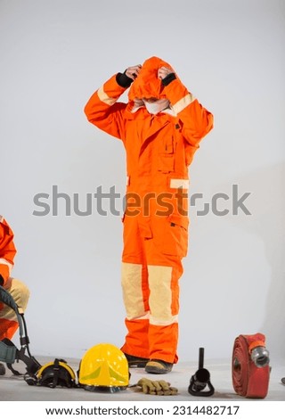 Professional firefighter is trying to take off his firefighter uniform hood on a white background, Firefighter equipment.