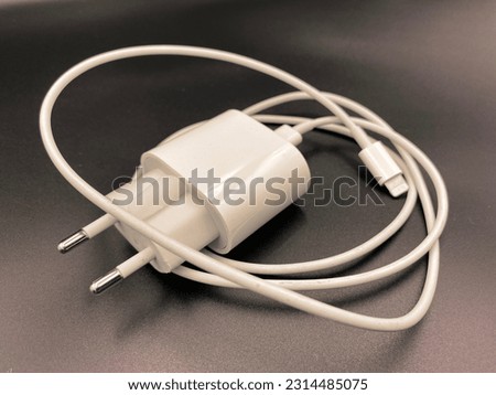 White charging phone with 1 meter cable, photographed on black background