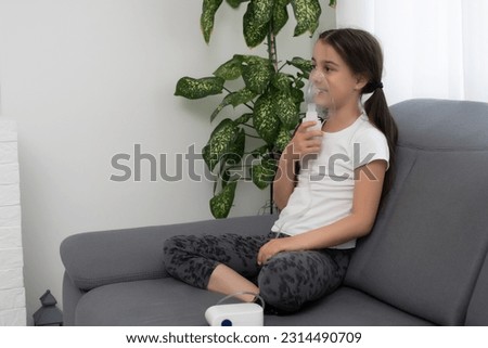 Little girl making inhalation with nebulizer at home. child asthma inhaler inhalation nebulizer steam sick cough concept. Royalty-Free Stock Photo #2314490709