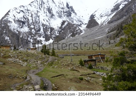 Landscape in the mountains, beautiful mountain lodge, lush trees on the slopes of mountains with blue sky and copy space.
