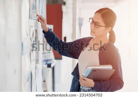 University school teen girl looking for job part time work post at campus advertising billboard. Royalty-Free Stock Photo #2314504703