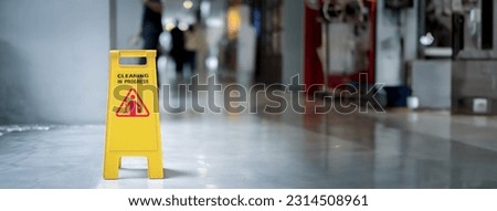 yellow plastic cone with sign showing warning of wet floor in restaurant in department store -panoramic banner