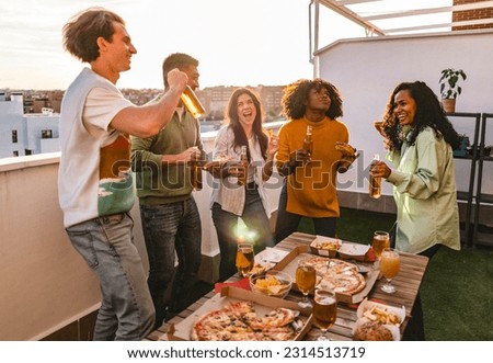 group of multiracial millennial friends on rooftop party