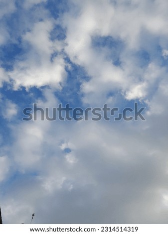 White clouds in the blue sky. Beautiful bright blue background. Light cloudy, good weather. Curly clouds on a sunny day.
