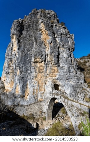 View of the traditional stone Kokkorou Bridge in Epirus, Greece in Autumn
