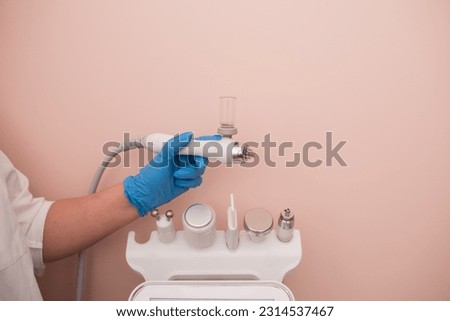 The cosmetologist includes a device for carrying out the procedure, attachments to the HydraFacial device for facial skin care in a spa clinic to combat acne or aging. The concept of aesthetic medicin Royalty-Free Stock Photo #2314537467