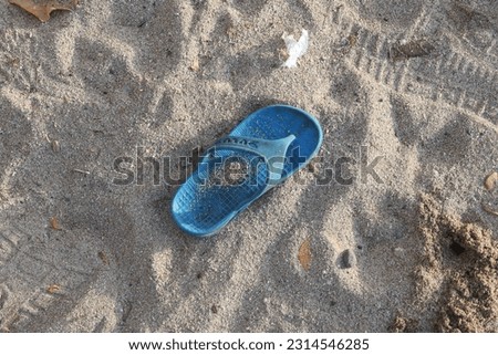 Blue children's sandals lost on the beach