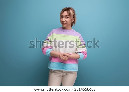 preppy blond woman in casual outfit on blue background with copy space