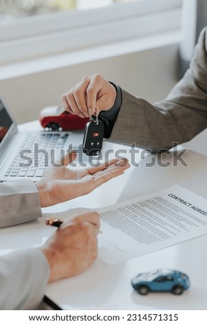 Car rental company service business, dealer hand giving, holding car keys to tenant customer, new owner after signing lease contract, purchase agreement in document, car sale contract.