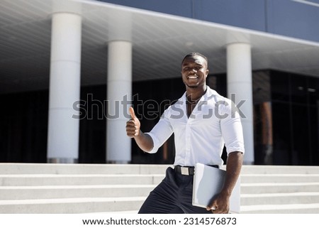 successful african businessman with hand gesture with laptop	