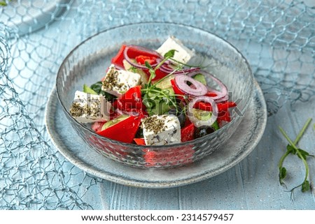 Greek salad with feta cheese, tomatoes, olives on a blue background. Mediterranean Kitchen. Sea mood menu. Royalty-Free Stock Photo #2314579457