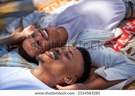 Close up happy, affectionate young gay male couple laying on blanket and looking up Royalty-Free Stock Photo #2314583285