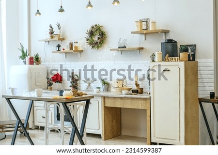 Bright kitchen interior with Christmas decor and Christmas wreath. Kitchenware.