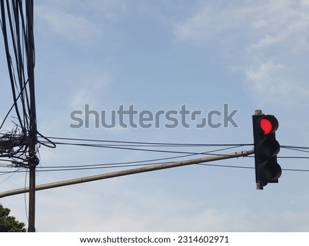 A traffic light with a red light against a clear sky background