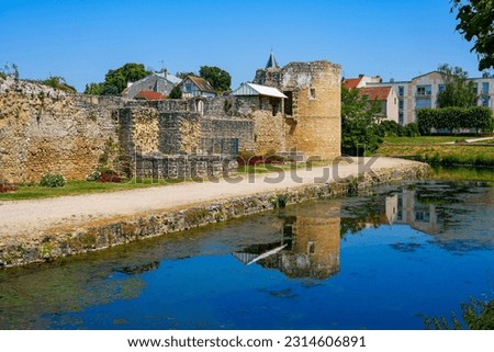 Water-filled moat below the round corner tower of the medieval castle of Brie Comte Robert in the French department of Seine et Marne in the capital region of Ile-de-France near Paris