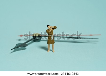 Miniature tiny people toy figure photography. A men wearing bathrobe getting shaving his beard standing in front of clockwise. Isolated on green background. Image photo
