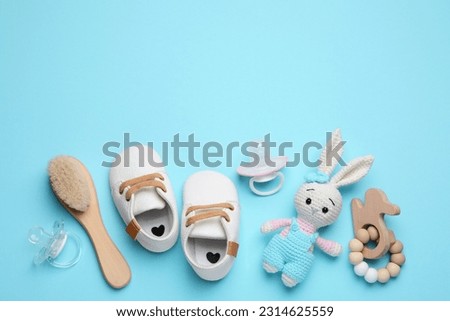 Flat lay composition with pacifiers and other baby stuff on light blue background. Space for text Royalty-Free Stock Photo #2314625559