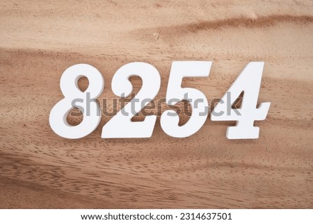 White number 8254 on a brown and light brown wooden background.