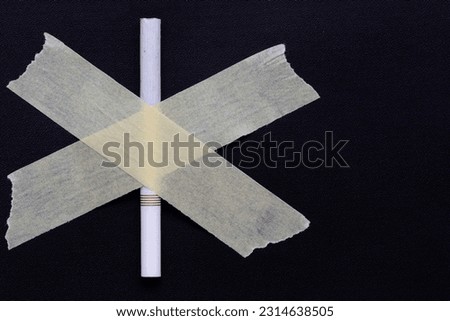 cigarette taped with cross sign on dark background, no smoking campaign concept.