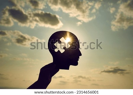 Concept of a human head with a puzzle in the middle. Finding a solution in the human brain. Concept of cognitive rehabilitation in Alzheimer's disease and dementia patien. Mental health. Royalty-Free Stock Photo #2314656001