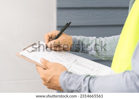 Building inspection, contractor asian young man, male inspecting home, reconstructed construction, renovation or check defect, before finish handing it over to client. Engineering worker, copy space. Royalty-Free Stock Photo #2314665561
